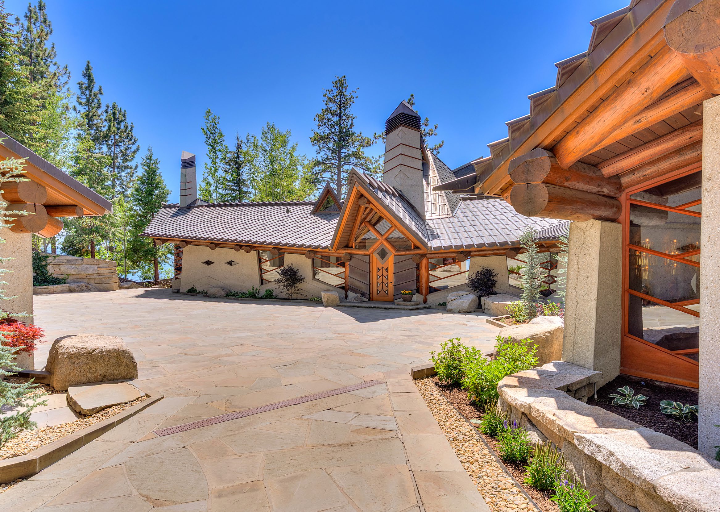 Timber, stone, and copper lakeside compound with flagstone courtyard among pines in Glenbrook, Nevada