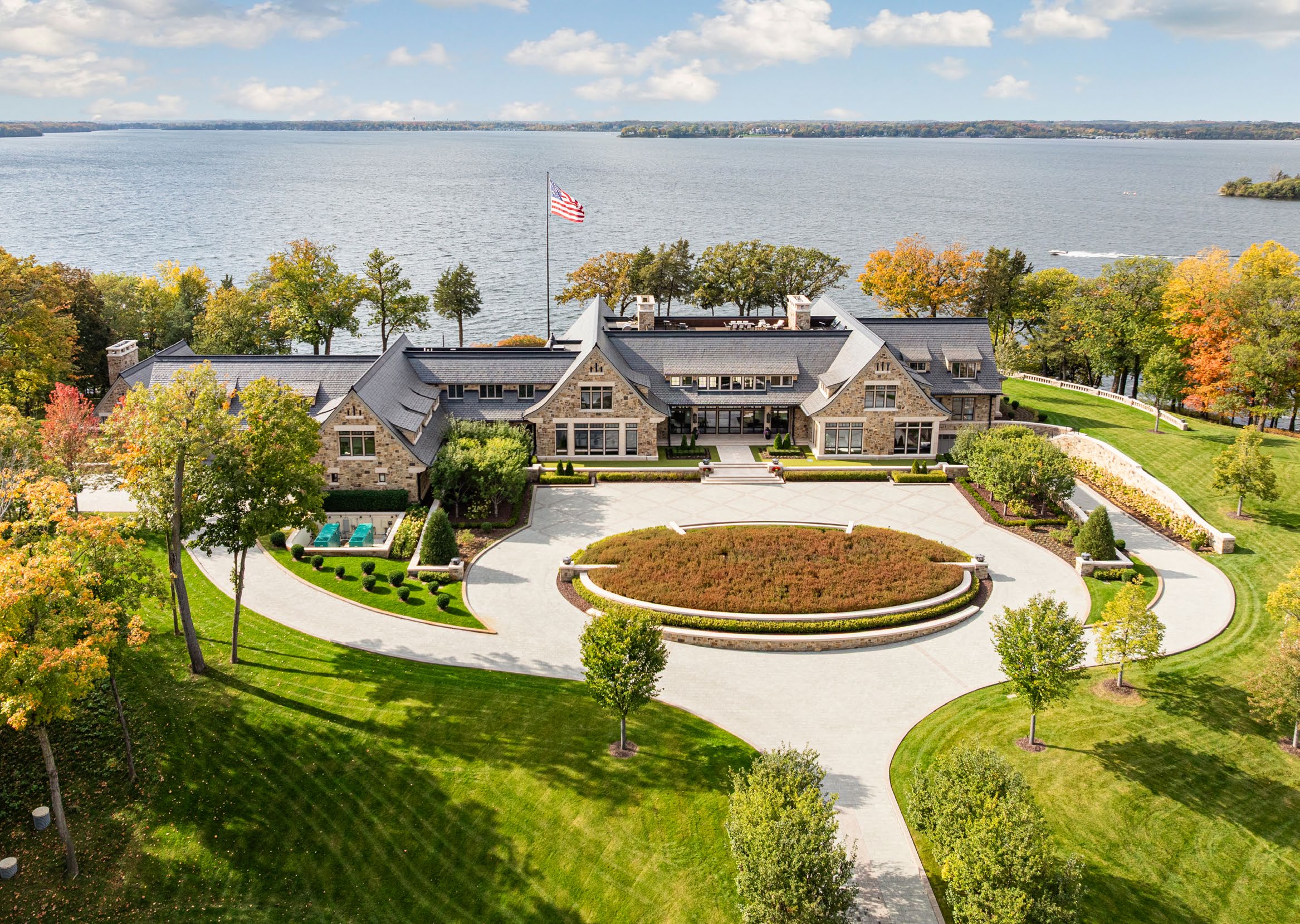Stone lakefront estate with circular motor court and autumn trees fronting Lake Minnetonka in Wayzata, Minnesota